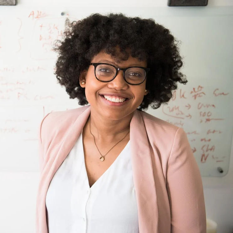 A woman standing in front of a whiteboard.