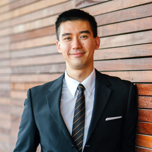 A smiling man wearing a suit.